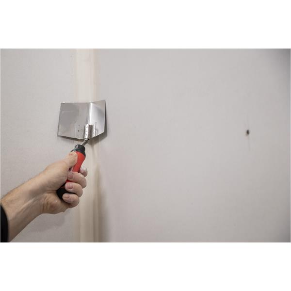 Person using WAL-BOARD TOOLS corner tool with soft grip handle on drywall joint