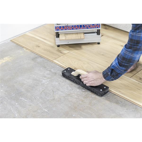 Person using a BULLET TOOLS Striker XXL Tapping Block on flooring installation