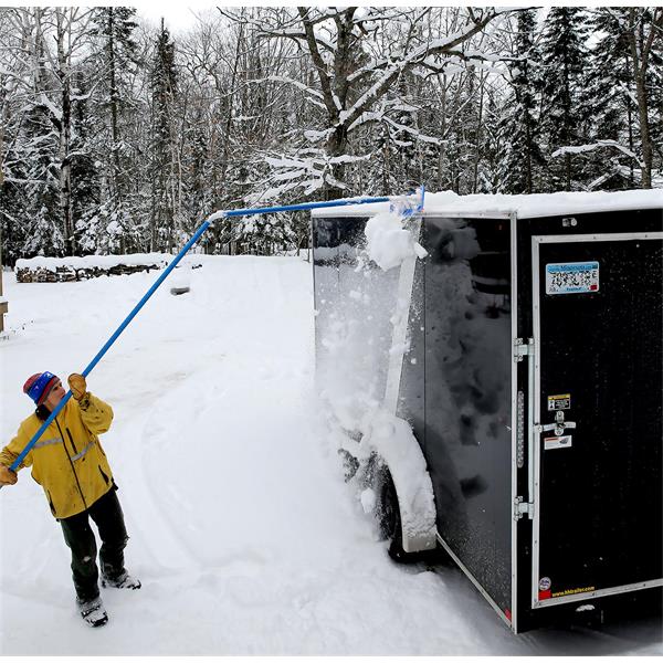 Person using a MARSHALLTOWN Big Rig Rake to clear snow off a large trailer