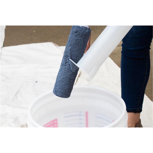 Person using a MARSHALLTOWN roller cleaner to rinse a paint roller