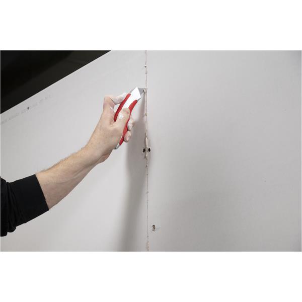 Person using a WAL-BOARD TOOLS utility knife on drywall