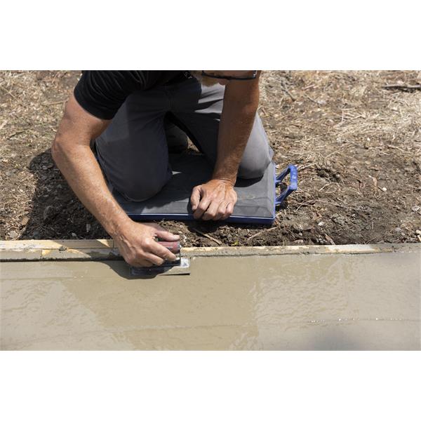 Person smoothing wet concrete using a tool while kneeling on MARSHALLTOWN kneeler boards