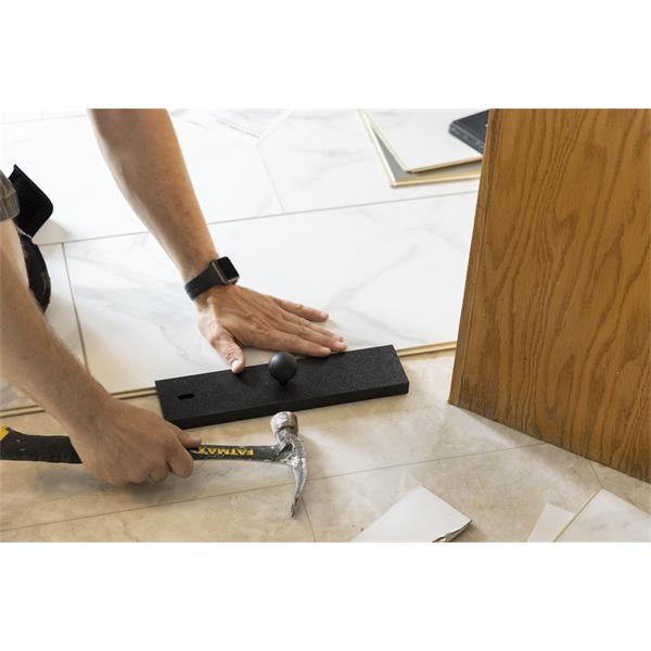 Person positioning BULLET TOOLS Pro Length Tapping Block during tile installation