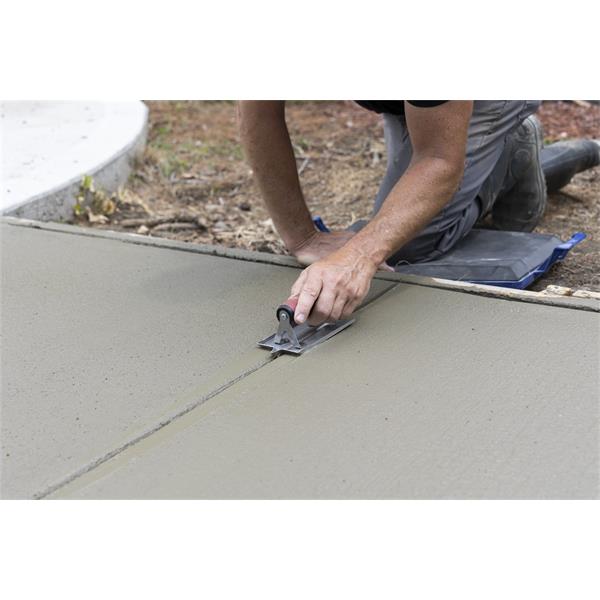 Person using a MARSHALLTOWN stainless steel hand groover on concrete