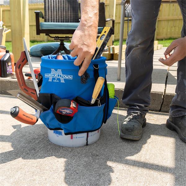 Construction worker using a MARSHALLTOWN Super Bucket Bag full of tools outdoors