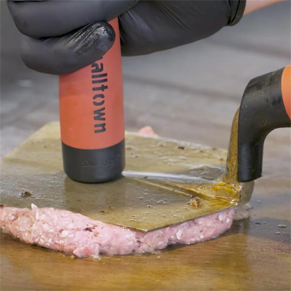 Person pressing meat with a MARSHALLTOWN hamburger trowel