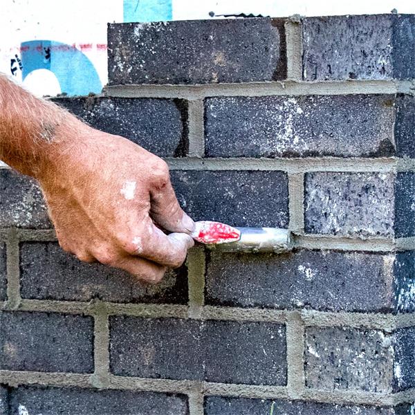 Close-up of a MARSHALLTOWN QLT barrel jointer being used on brick mortar