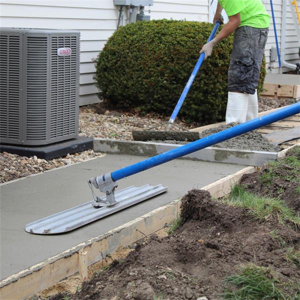 Worker using MARSHALLTOWN Rock-It on concrete walkway