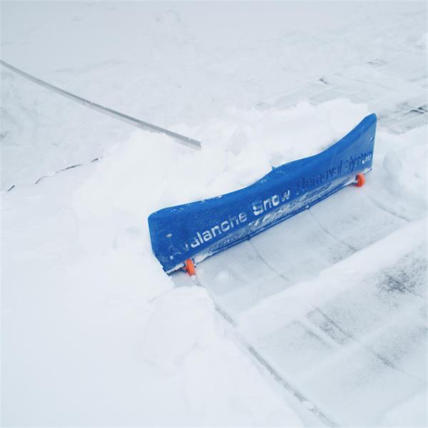 Detail-focused snow removal tool on a rooftop as part of an AVALANCHE combo package