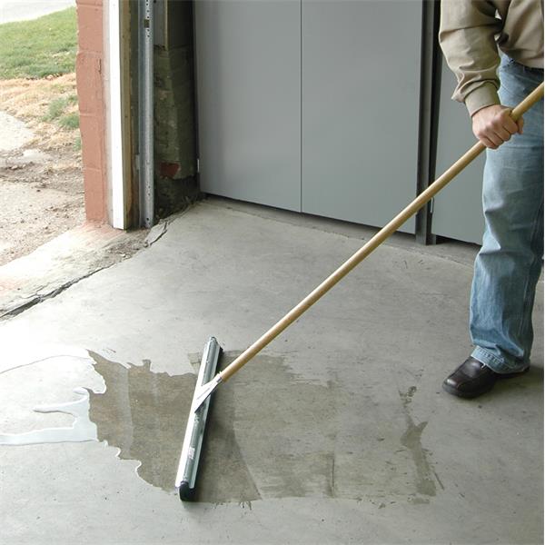 Person using a MARSHALLTOWN QLT Double Blade Floor Squeegee on concrete surface