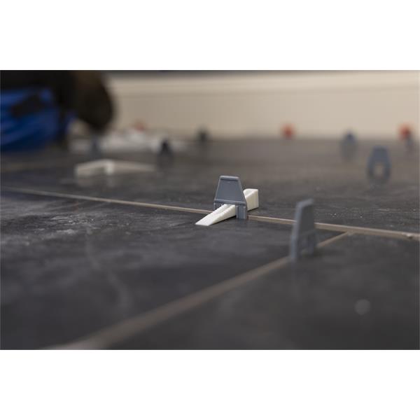 Close-up of a BARWALT PLS Tile Leveling System in use on installed floor tiles