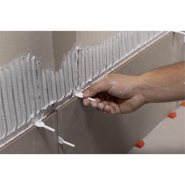 Close-up of hand using BARWALT PLS Revolve™ Tile Leveling System on wall tiles