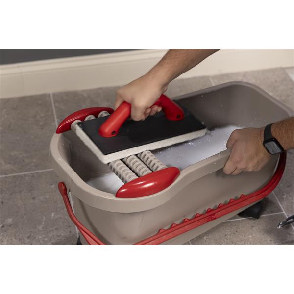 Close-up of hands using a BARWALT Ultra Grouting System on tile flooring